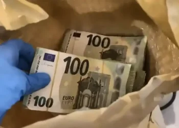 Policajac drži paket falsifikovanih novčanica od 100 evra